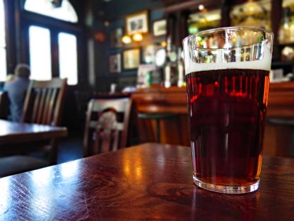 Pint of amber ale on a pub table.