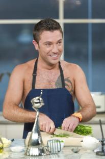 Gino D'Acampo cooking shirtless on a TV program.
