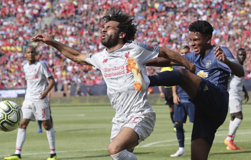 Mohamed Salah being fouled during a soccer match.