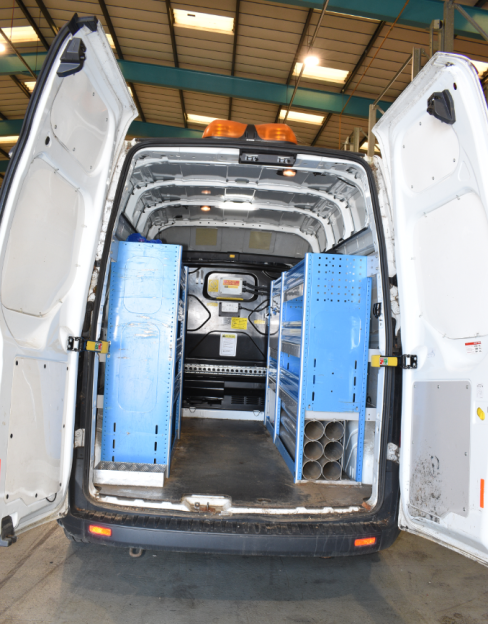 Rear interior of a white van used in a kidnapping, showing blue shelving units.