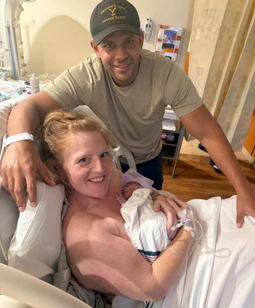 A mother and father holding their newborn baby in a hospital room.