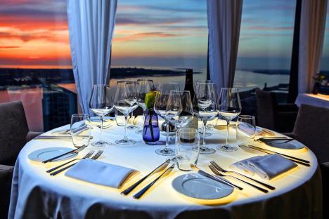 Table set for a romantic dinner with a sunset view.