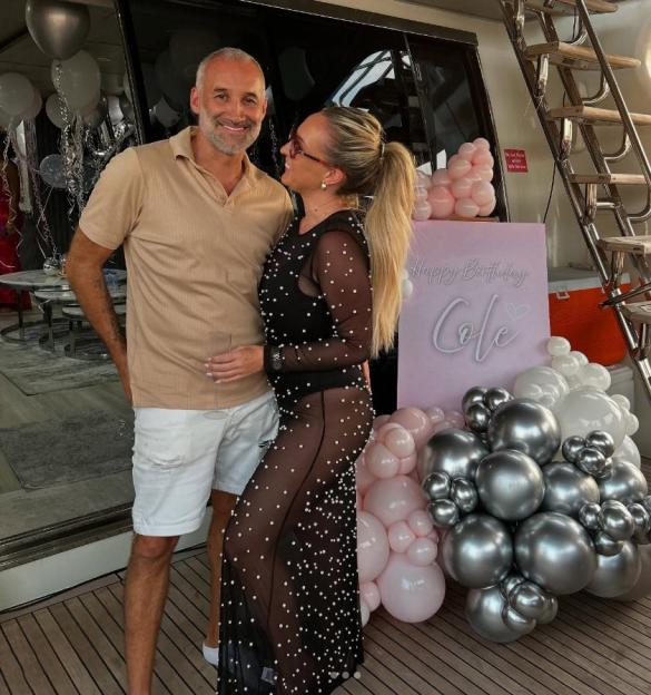 Dane Bowers and Nicole posing together on a yacht.