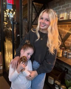 Teenage mother and young daughter holding a stuffed dog.