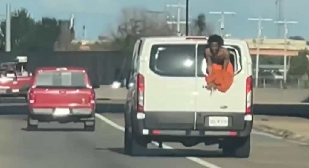 Shock moment pleading shirtless prisoner hangs out back of jail van speeding down road after smashing way out
