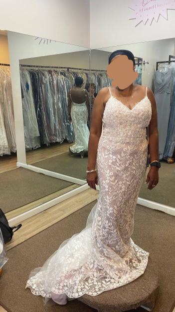 Woman in a lace wedding dress in a bridal shop.