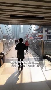 Person walking across a bridge in a city.