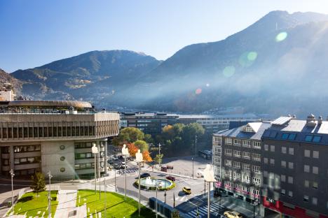 Andorra la Vella cityscape with sculptures and mountains in the background.