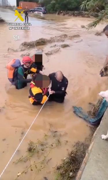 Police officers rescuing flood victims in Ibiza.