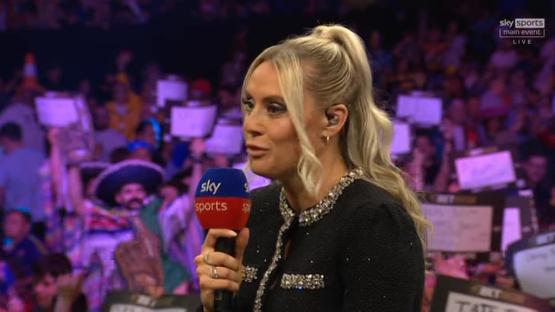 A woman holding a Sky Sports microphone speaks to a crowd.