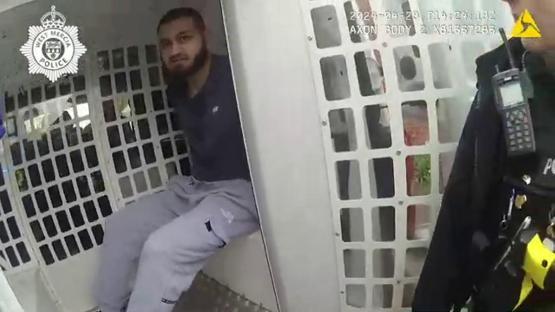 Arrested man in police vehicle.