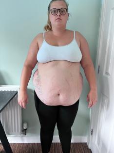 Woman in white bra and black leggings.