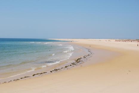 Beach scene with ocean waves lapping a sandy shore.