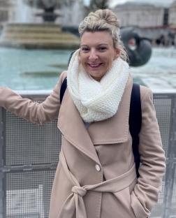 Woman in a beige coat and white scarf.