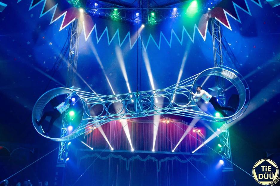Acrobats performing on a rotating "Wheel of Death" at Paul Busch Circus.