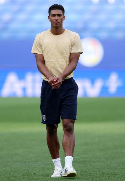 Jude Bellingham of England inspects the pitch during a stadium walk.
