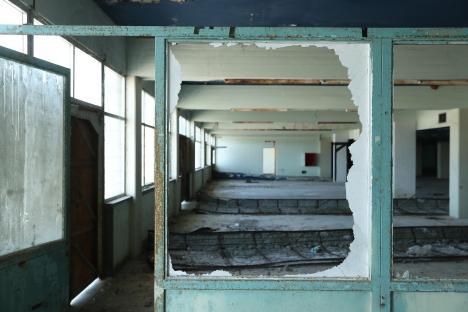 A broken window looks through to the former baggage claim hall 