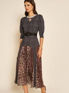 Woman in polka dot and leopard print midi dress.