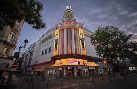 The Grand Rex cinema in Paris at dusk, showing a My Hero Academia movie poster.
