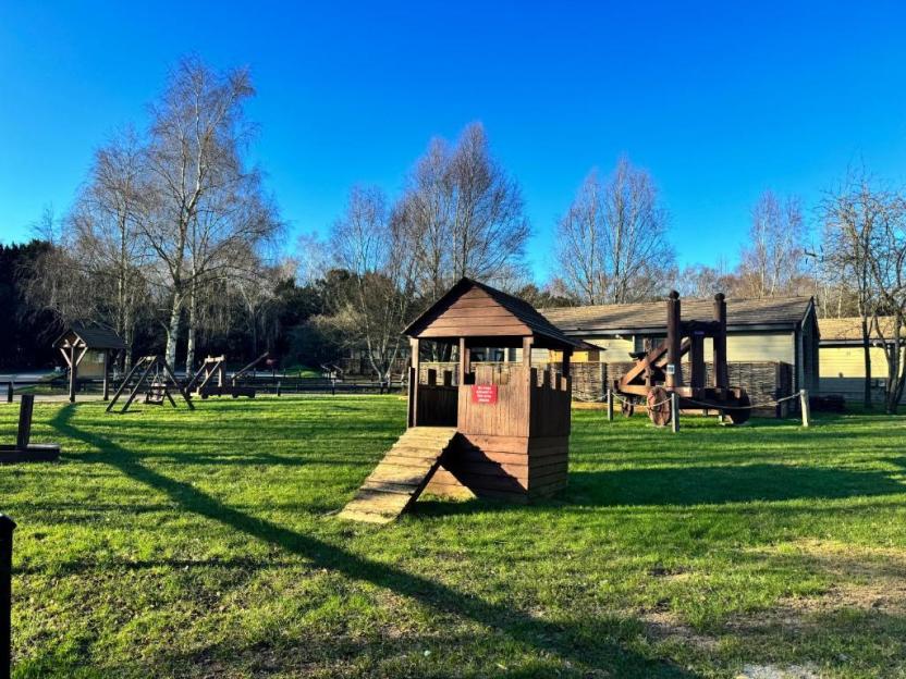 Playground with wooden play structures and a large wooden catapult.