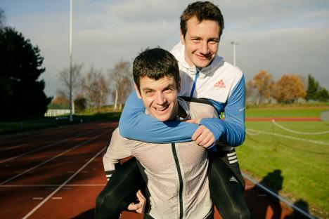 Jonny and Alistair Brownlee brothers on a running track.