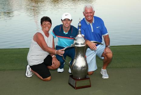 Rory McIlroy with his parents and a trophy.
