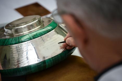 Engraving the Premier League trophy with Liverpool's name as 2025 champions.