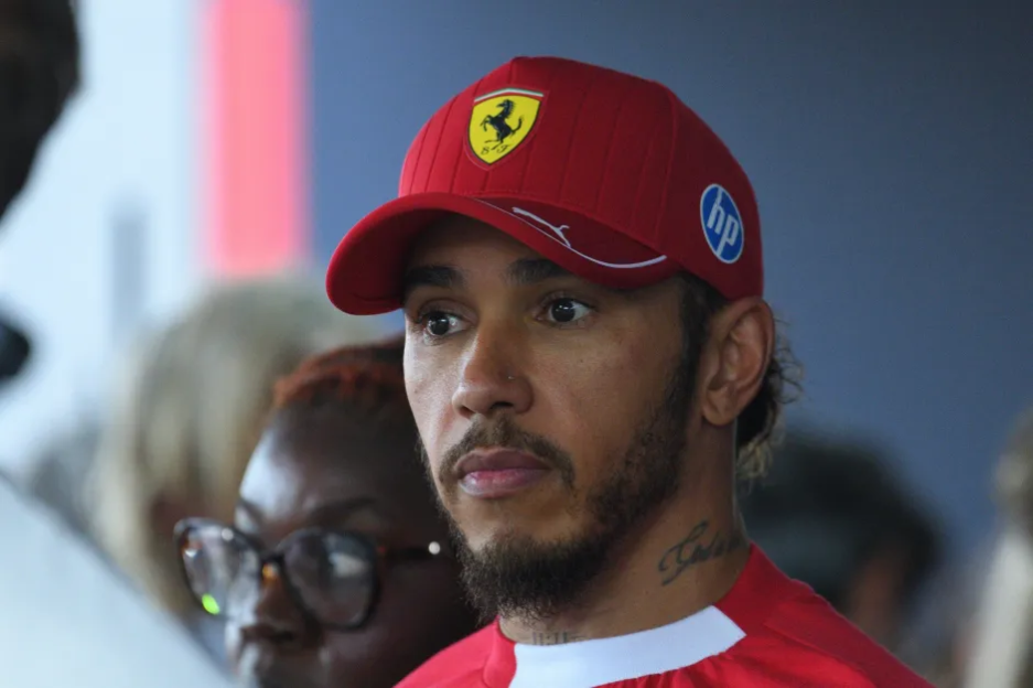 Lewis Hamilton wearing a red Ferrari hat.