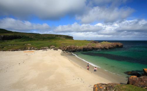 A mother and two daughters on a sandy beach in Scotland.