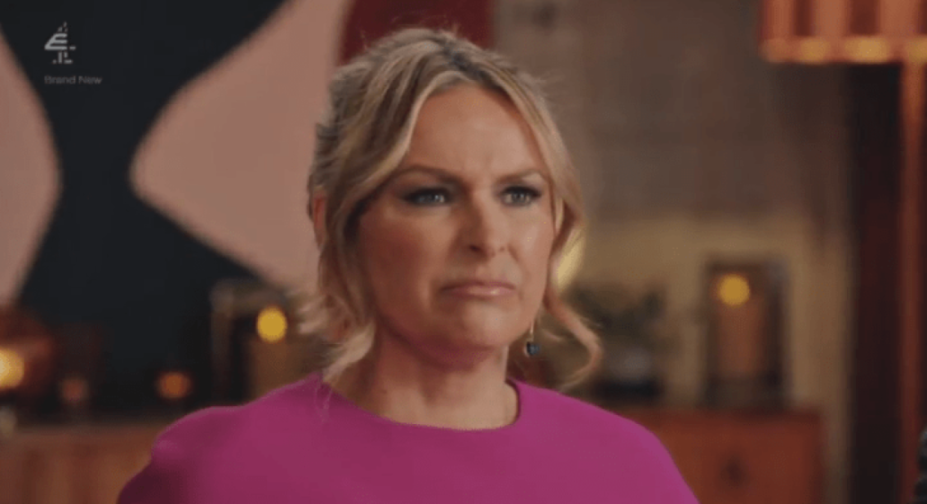 A blonde woman in a magenta top looking displeased.