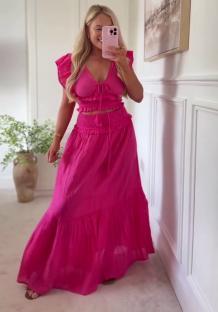 Woman in a pink two-piece outfit taking a selfie.