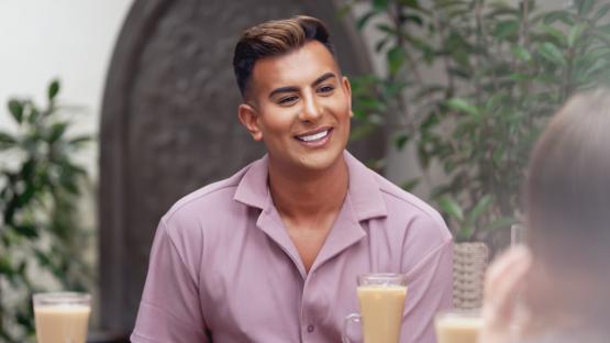 Man smiling at a cafe.