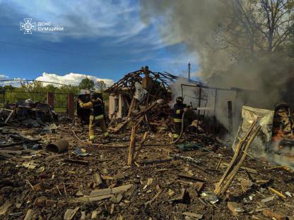 Firefighters extinguishing a fire at a damaged building in Bilopillya, Ukraine.