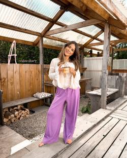 Woman holding a mug in a wooden structure.