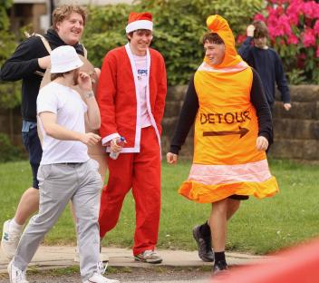 People in costumes walking down a sidewalk.
