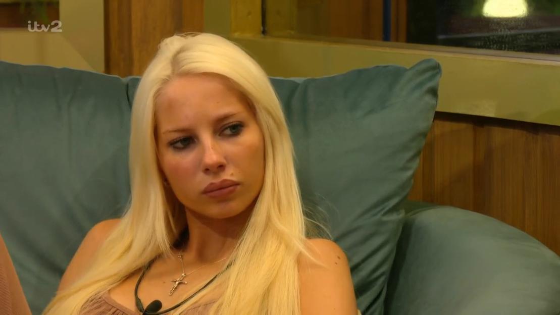 Lucy from Big Brother looking on with a slight frown.