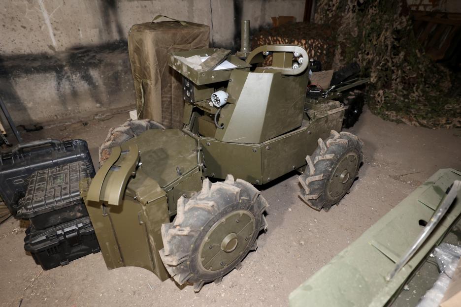Unmanned Ground Vehicle (UGV) with infrared lights, a camera, and a machine gun turret.