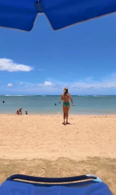 Woman in bikini walking on a beach.