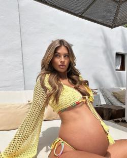 Pregnant woman in yellow crochet bikini top and tie-dye bikini bottom.