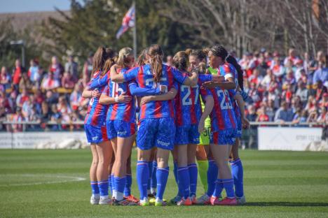 Crystal Palace women's soccer team huddles on the field.
