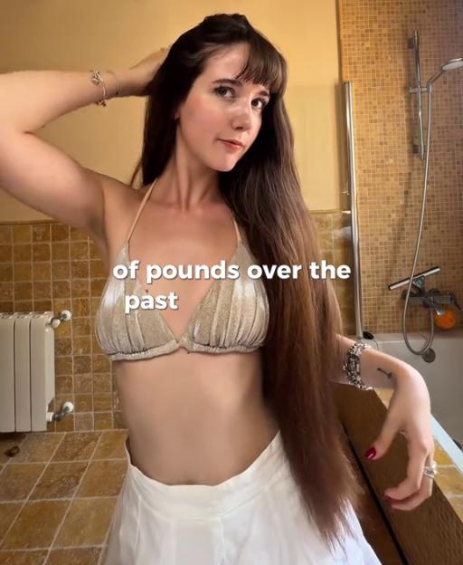 Woman showing off her long hair in a bathroom.