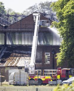 Firefighters extinguishing a fire at a brick building.