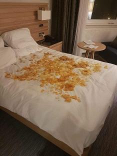 Hotel bed covered in crisps after a miscommunication with staff.