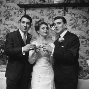 April 1965: Frances Shae toasting to future happiness with the Kray twins, after her marriage to Reggie Kray, right. (Photo by Norman Potter/Express/Getty Images)