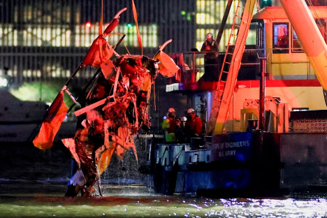Debris from a helicopter being recovered from the water by a US Army Corps of Engineers vessel.