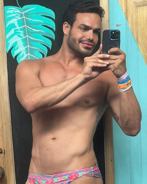 Emilio Sueños taking a shirtless mirror selfie.