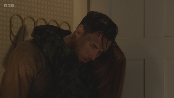 Screenshot of a man and woman embracing.