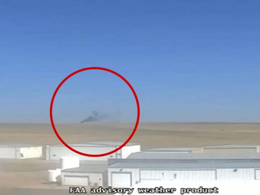 Smoke billowing from a mid-air plane crash.