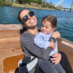 Woman holding a toddler on a boat.