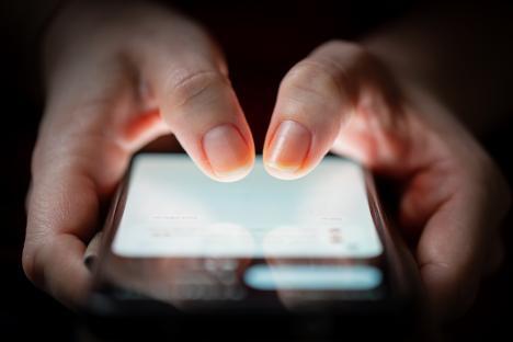 Close-up of two thumbs using a smartphone.